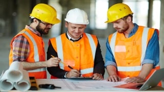 3 construction workers reviewing job site safety